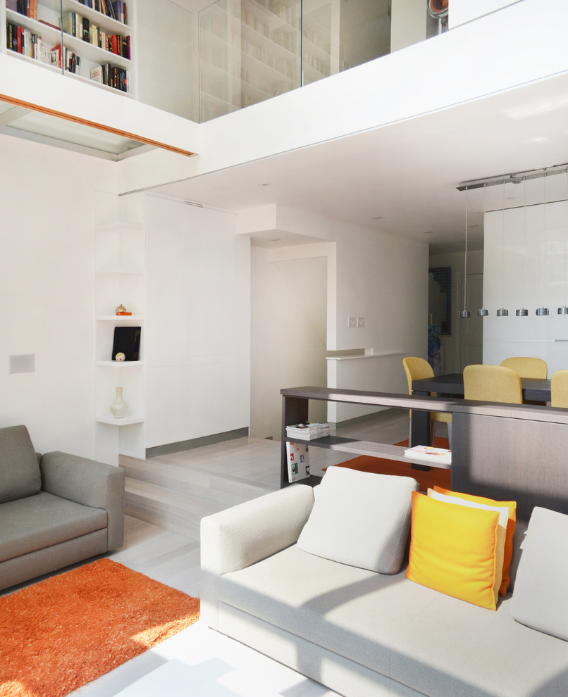 На фото: огромная открытая гостиная комната в современном стиле с белыми стенами, светлым паркетным полом, горизонтальным камином и фасадом камина из металла с