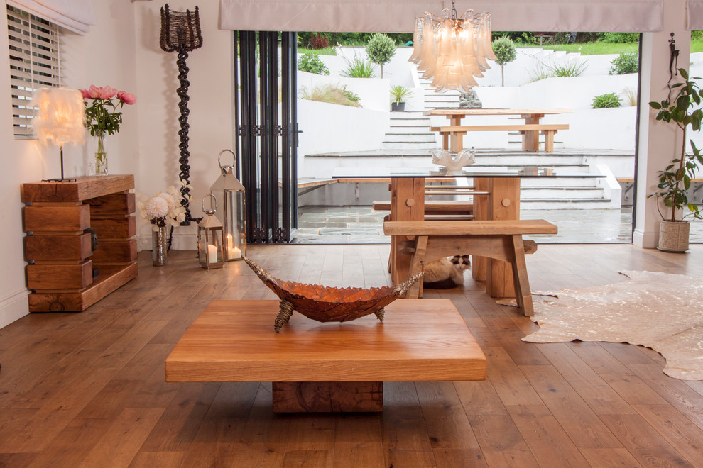 Imagen de salón abierto minimalista de tamaño medio sin chimenea y televisor con paredes blancas y suelo de madera en tonos medios