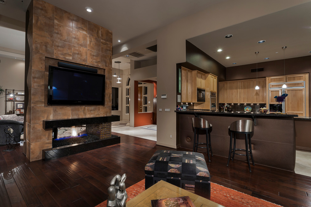 Large contemporary open plan living room in Phoenix with multi-coloured walls, dark hardwood flooring, a two-sided fireplace, a tiled fireplace surround and a wall mounted tv.