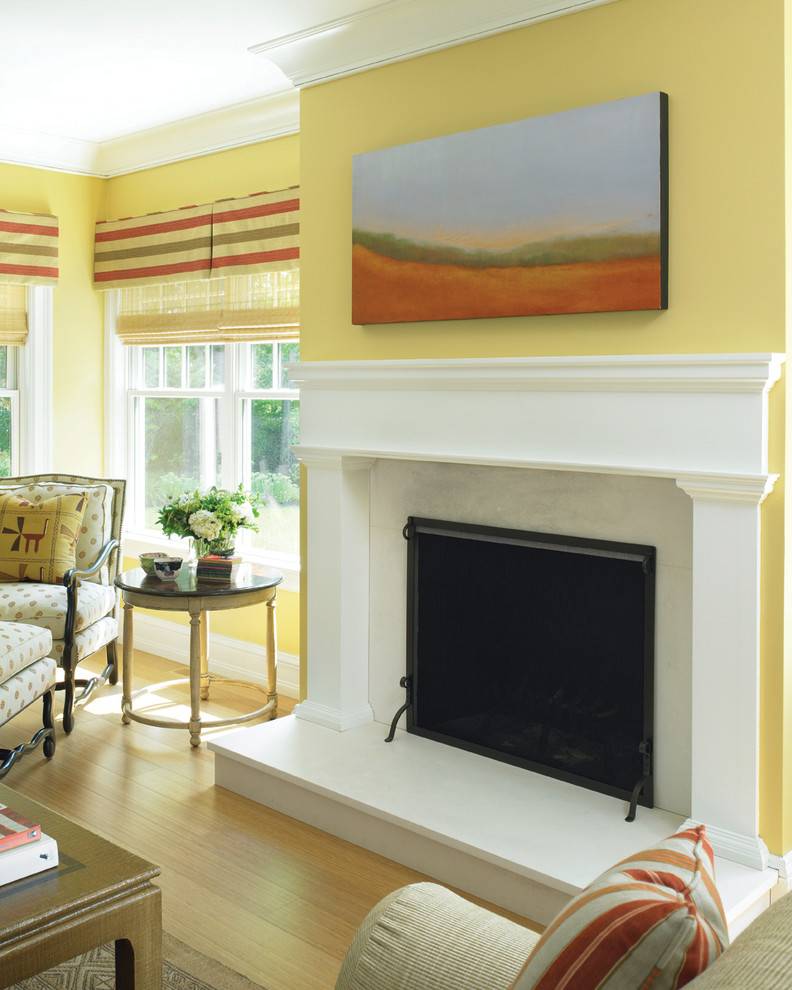 Klassisches Wohnzimmer mit gelber Wandfarbe, hellem Holzboden und Kamin in Boston