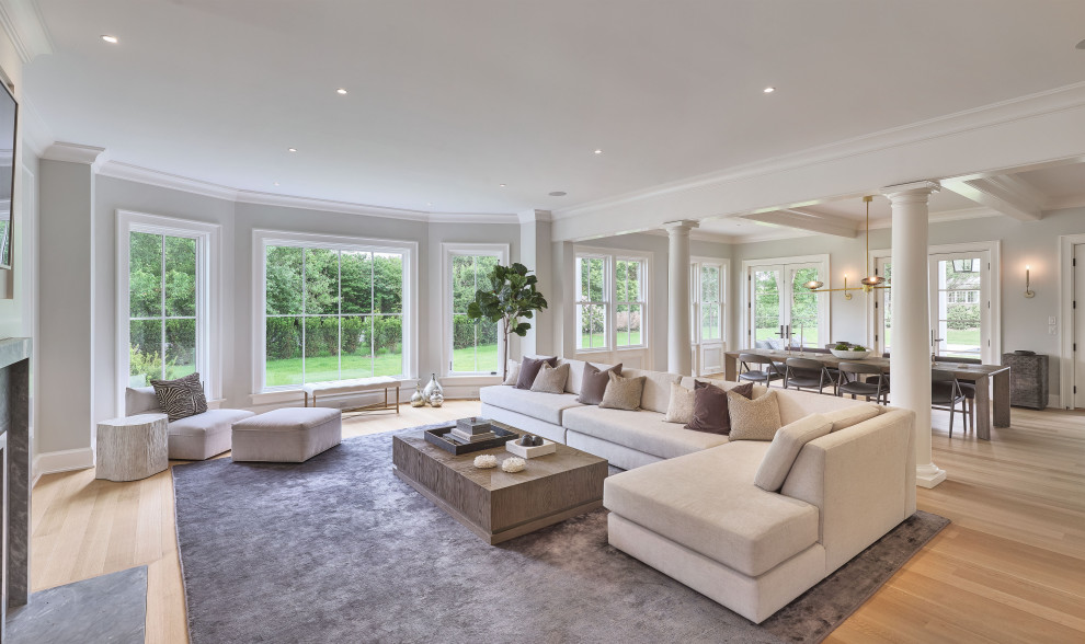Immagine di un ampio soggiorno classico aperto con pareti grigie, parquet chiaro e pavimento beige