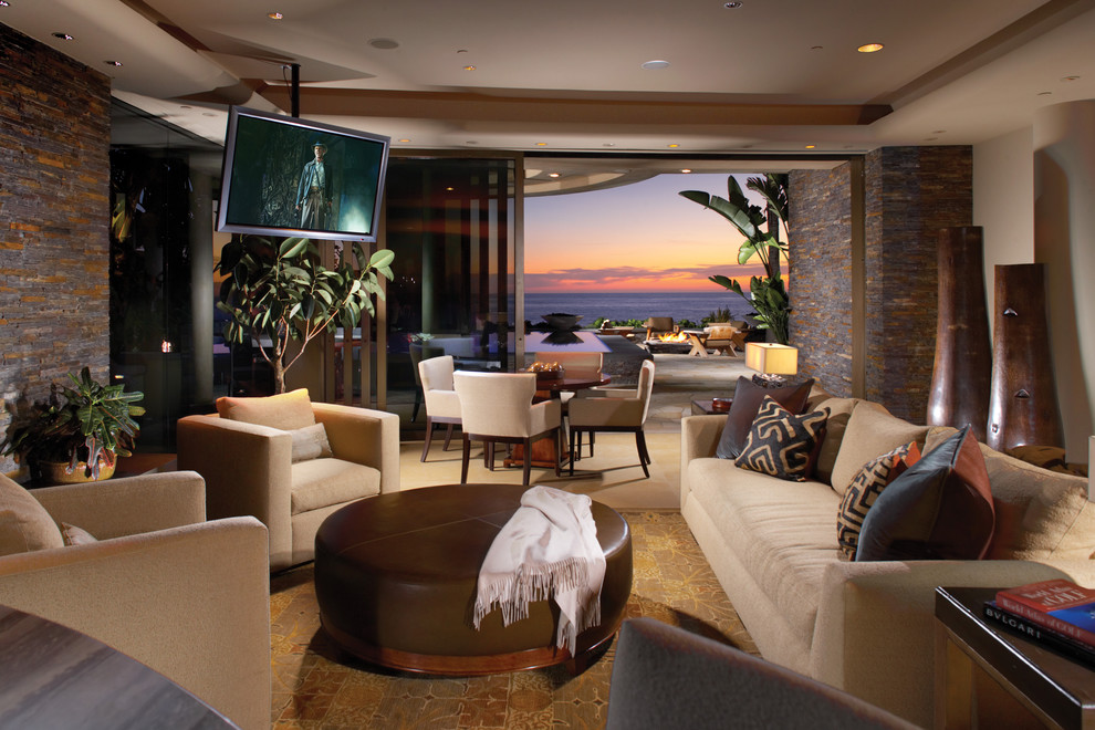 This is an example of a world-inspired open plan living room in Orange County with beige walls.