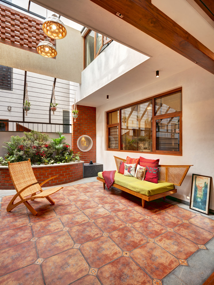 Diseño de galería contemporánea con suelo de baldosas de terracota, techo con claraboya y suelo marrón