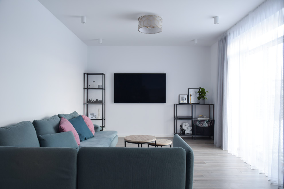 Diseño de salón abierto escandinavo de tamaño medio con paredes blancas, suelo de baldosas de cerámica y televisor colgado en la pared