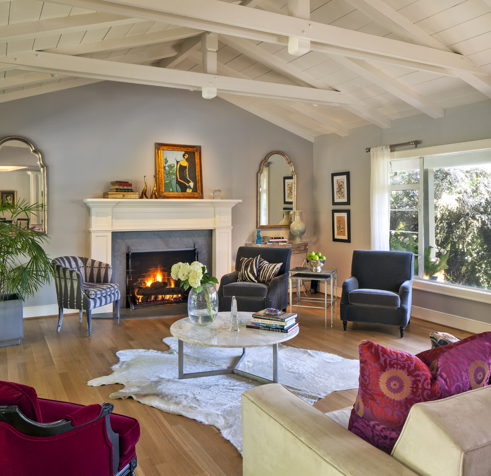Photo of an eclectic living room in San Francisco with blue walls and a standard fireplace.
