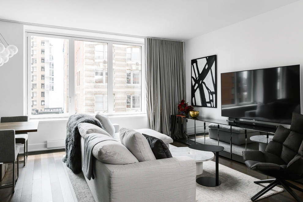 Источник вдохновения для домашнего уюта: открытая гостиная комната в современном стиле с белыми стенами, темным паркетным полом, отдельно стоящим телевизором и коричневым полом без камина