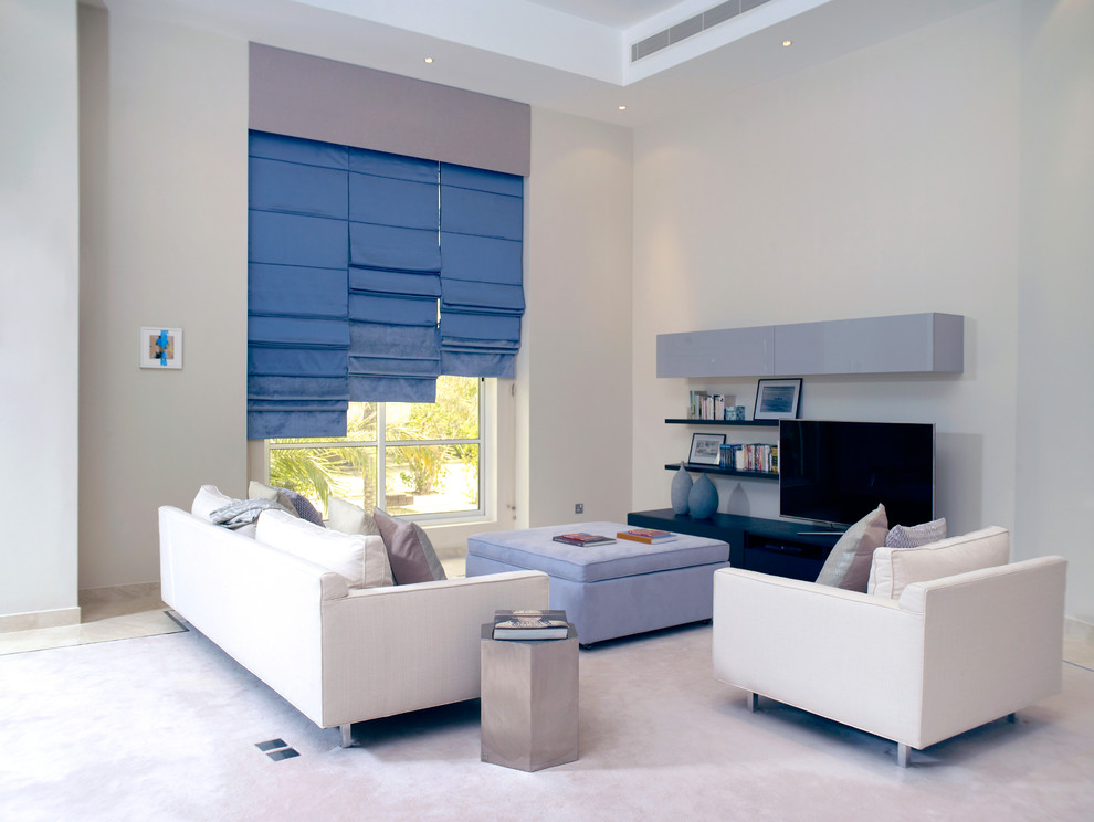 Idée de décoration pour un salon design avec un mur gris et un téléviseur indépendant.