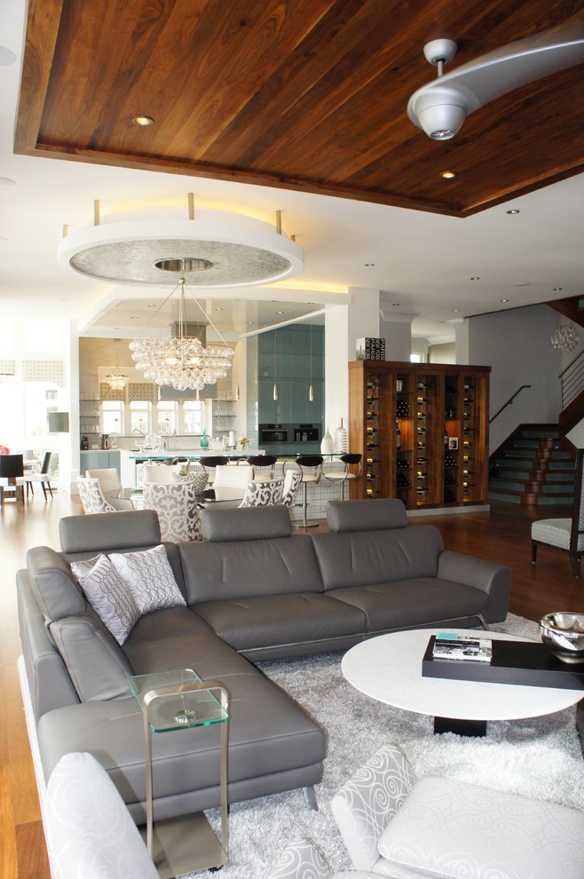 Großes, Repräsentatives, Offenes Modernes Wohnzimmer mit grauer Wandfarbe, braunem Holzboden, Kamin, gefliester Kaminumrandung und Multimediawand in Miami