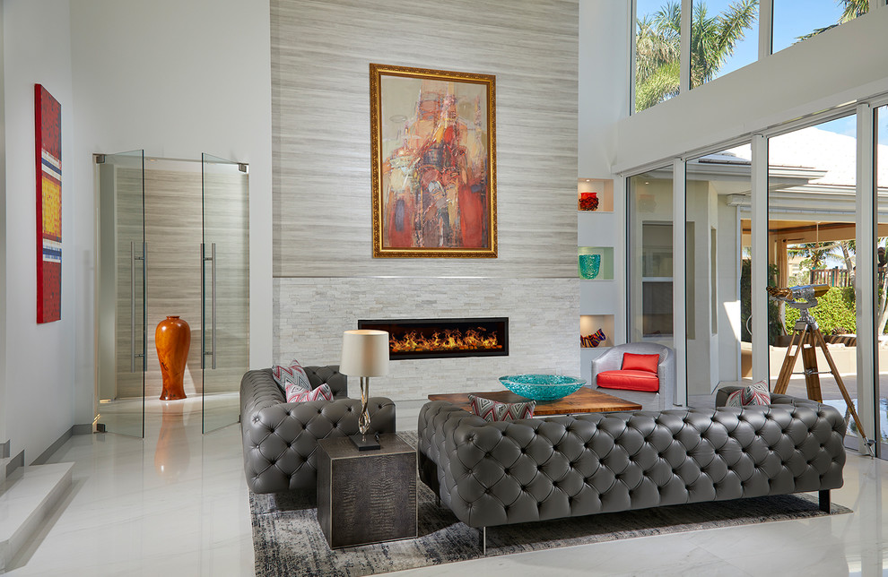 マイアミにあるコンテンポラリースタイルのおしゃれな応接間 (グレーの壁、横長型暖炉、石材の暖炉まわり、グレーの床) の写真