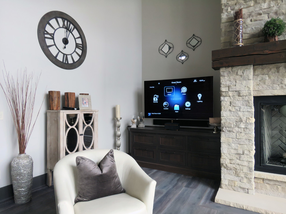 На фото: гостиная комната в стиле неоклассика (современная классика) с серыми стенами, светлым паркетным полом, стандартным камином, фасадом камина из камня, отдельно стоящим телевизором и серым полом с