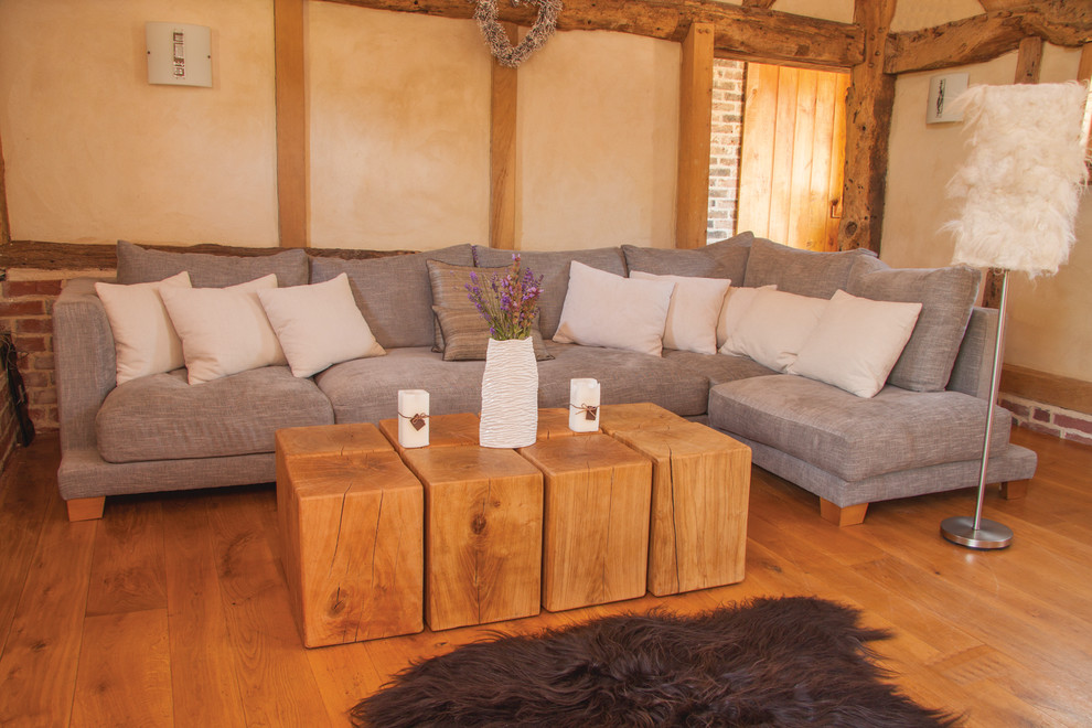 Foto di un grande soggiorno stile rurale aperto con pareti beige, pavimento in legno massello medio e TV a parete