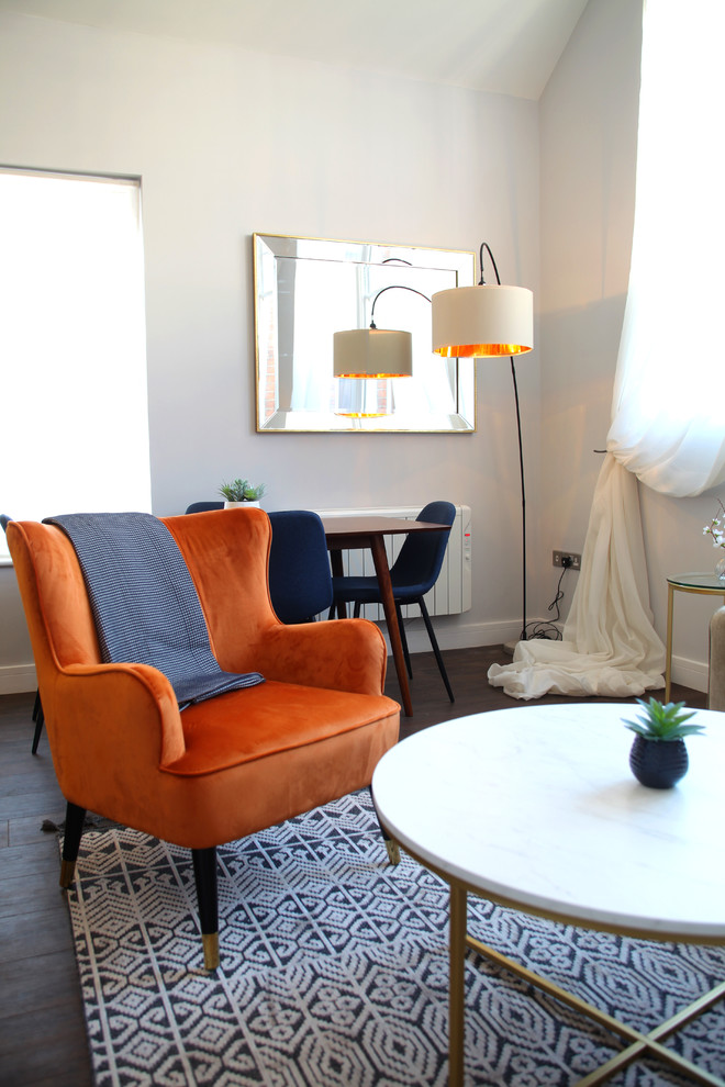 Стильный дизайн: маленькая открытая гостиная комната:: освещение в стиле фьюжн с серыми стенами, полом из ламината, телевизором на стене и коричневым полом без камина для на участке и в саду - последний тренд