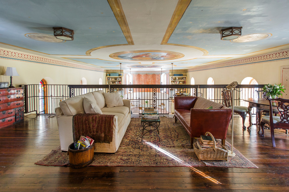 Imagen de salón para visitas tipo loft tradicional grande sin chimenea y televisor con paredes blancas, suelo de madera en tonos medios y suelo marrón