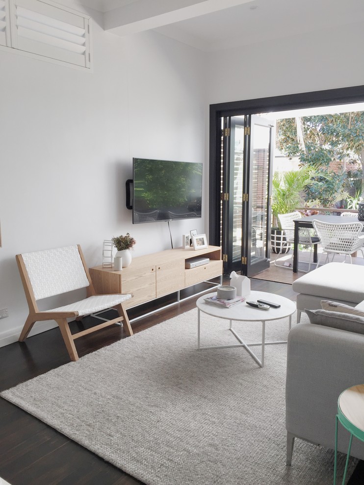 Mittelgroßes, Offenes Nordisches Wohnzimmer ohne Kamin mit weißer Wandfarbe, dunklem Holzboden und TV-Wand in Sydney