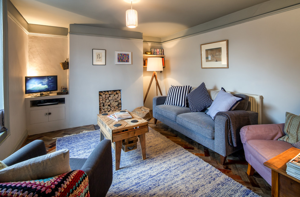 Idee per un piccolo soggiorno minimal chiuso con pareti blu e pavimento in legno verniciato