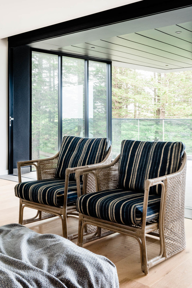 Foto di un ampio soggiorno costiero chiuso con pareti bianche, pavimento in legno massello medio e pavimento marrone