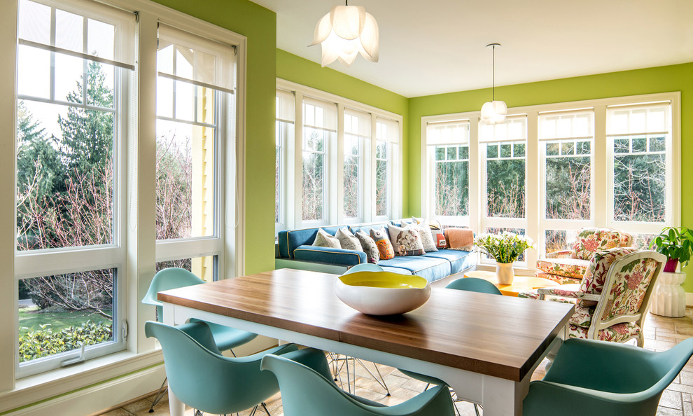 На фото: открытая гостиная комната в стиле фьюжн с зелеными стенами и синим диваном с