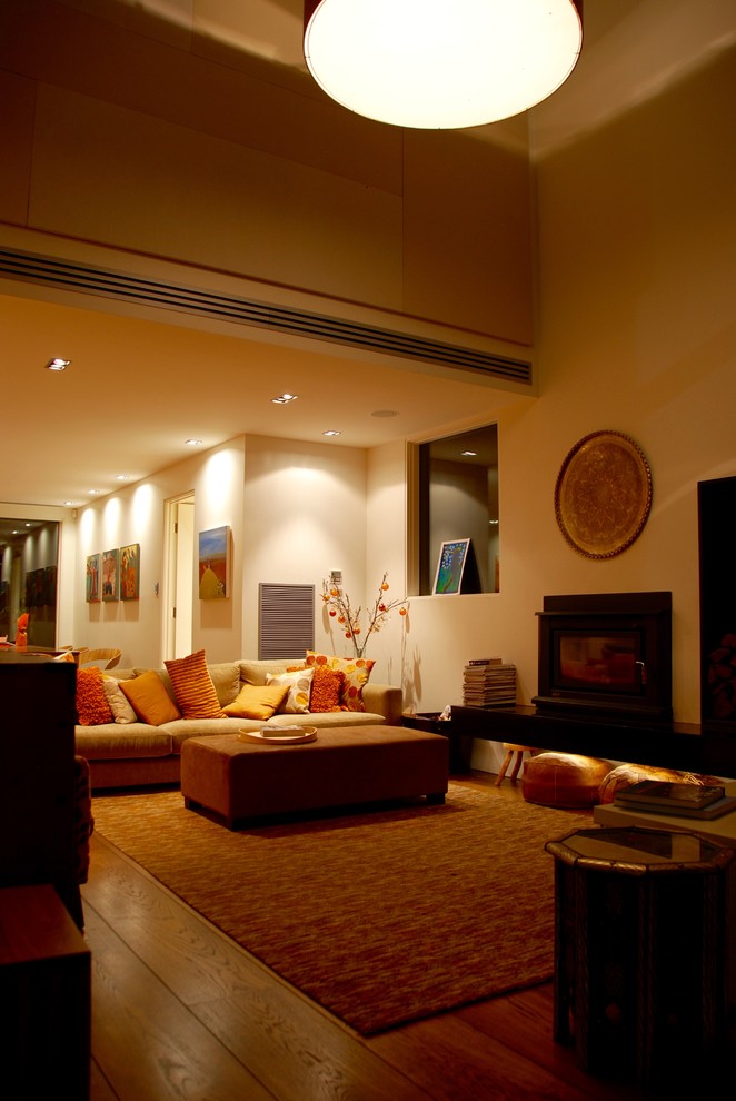 На фото: парадная, открытая гостиная комната в современном стиле с белыми стенами, ковровым покрытием, стандартным камином и фасадом камина из камня без телевизора