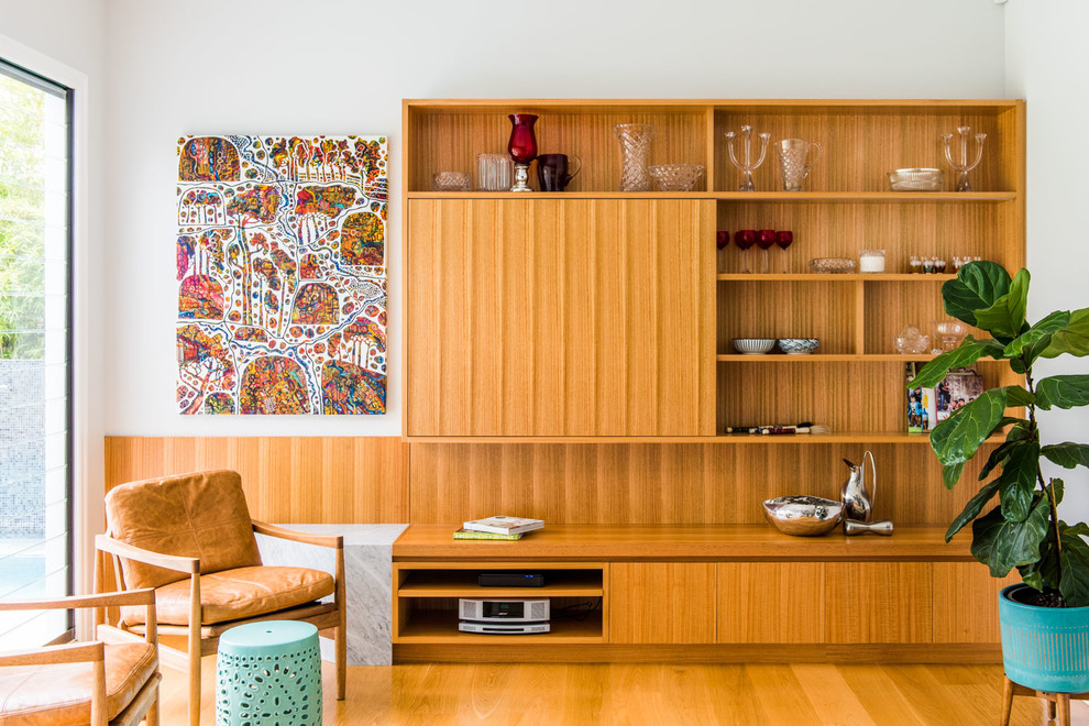 Modernes Wohnzimmer mit weißer Wandfarbe, braunem Holzboden, braunem Boden und verstecktem TV in Brisbane