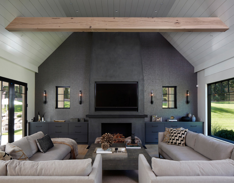 На фото: большая гостиная комната в стиле неоклассика (современная классика) с серыми стенами, стандартным камином, телевизором на стене, серым полом и деревянным потолком