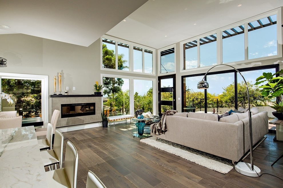 Inspiration for a large contemporary open concept light wood floor living room remodel in San Diego with gray walls, a standard fireplace, a tile fireplace and a wall-mounted tv