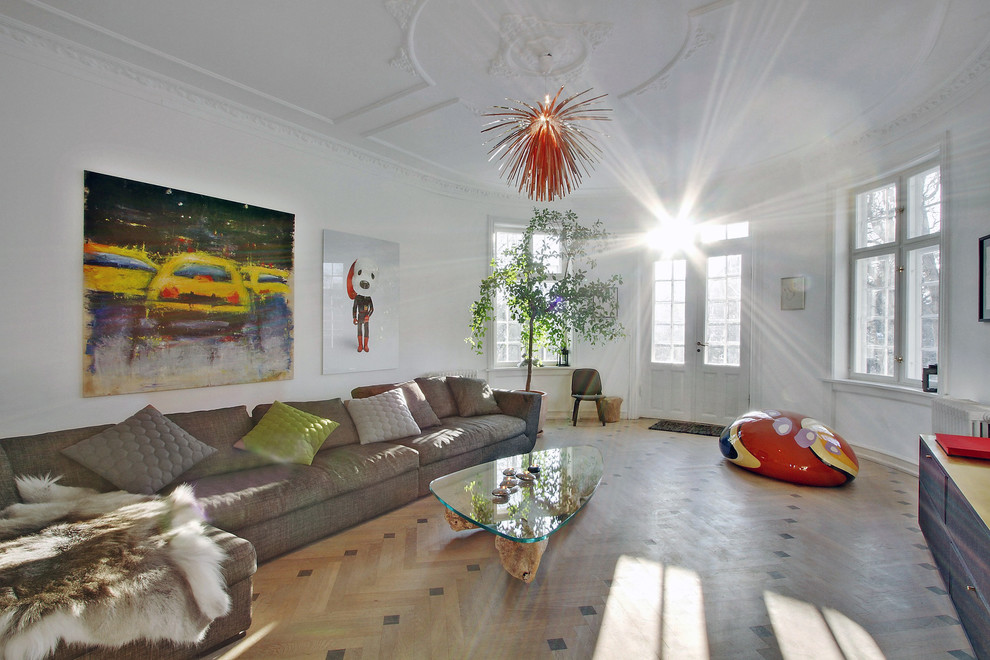 Immagine di un grande soggiorno design con pareti bianche, pavimento in legno massello medio e nessun camino