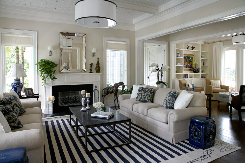 Foto di un soggiorno classico aperto con sala formale, pareti beige, parquet scuro, camino classico e pavimento marrone