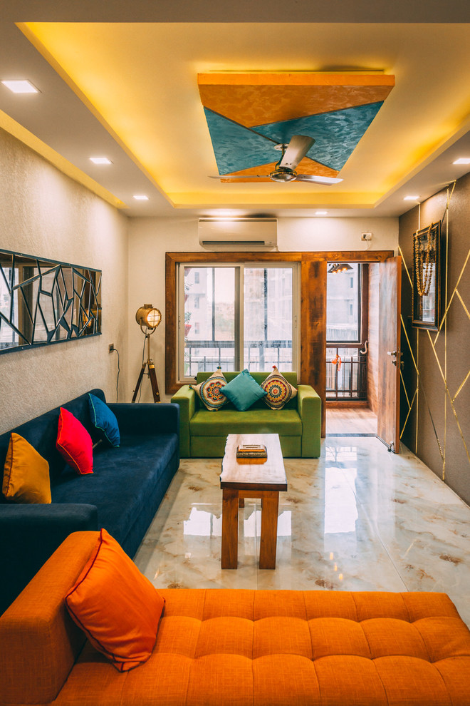 Стильный дизайн: гостиная комната в стиле фьюжн с бежевыми стенами, бежевым полом и синим диваном - последний тренд