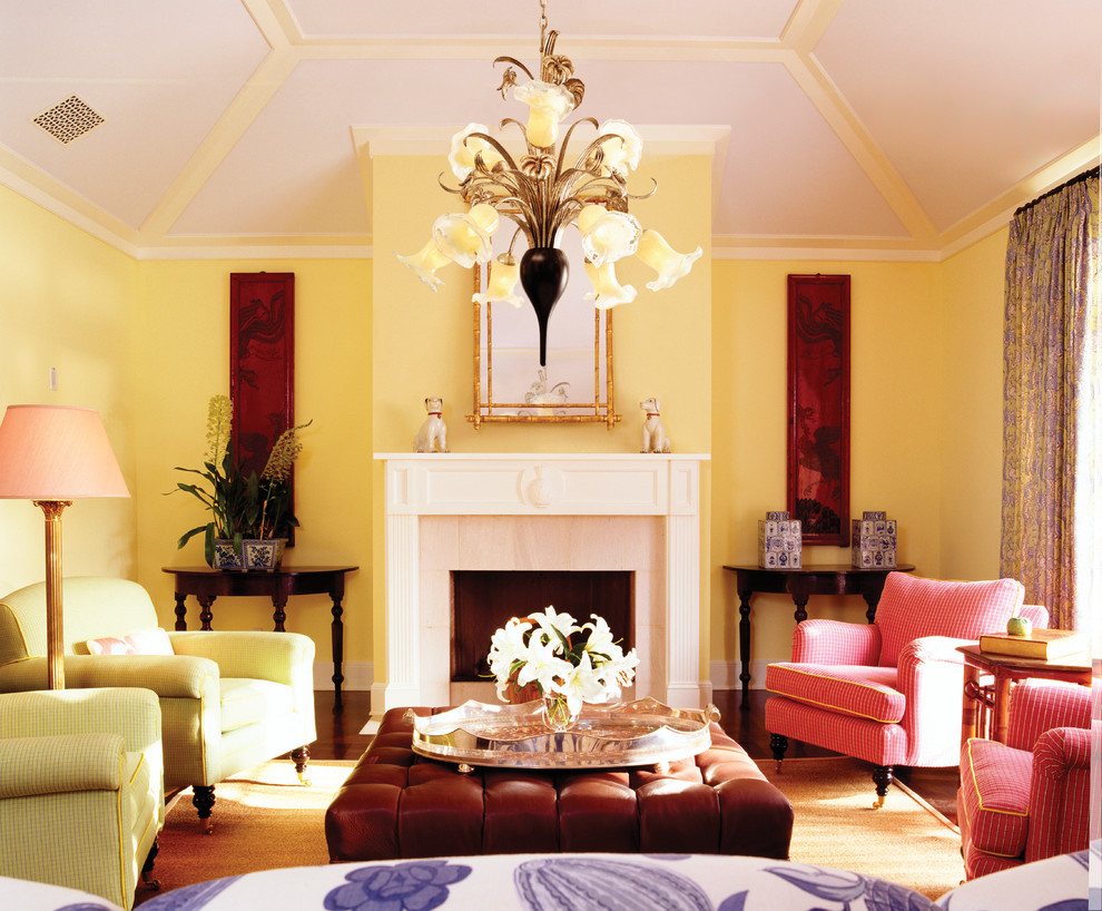 Foto di un soggiorno contemporaneo con pareti gialle e camino classico
