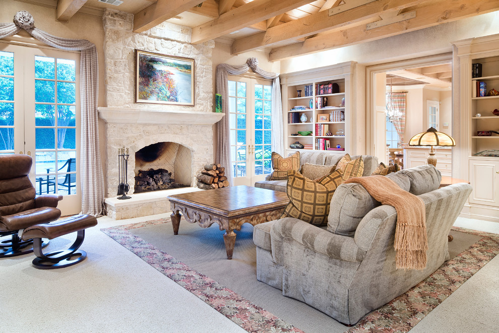 Cette photo montre un salon avec un mur beige, moquette, une cheminée standard, un manteau de cheminée en pierre et éclairage.