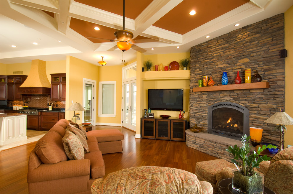 Example of a classic living room design in DC Metro with yellow walls, a corner fireplace, a stone fireplace and a wall-mounted tv