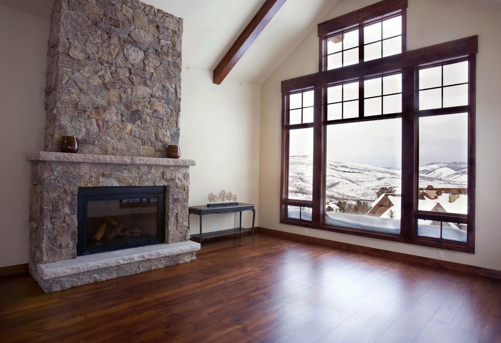 デンバーにある中くらいなトラディショナルスタイルのおしゃれなリビング (白い壁、濃色無垢フローリング、標準型暖炉、石材の暖炉まわり) の写真