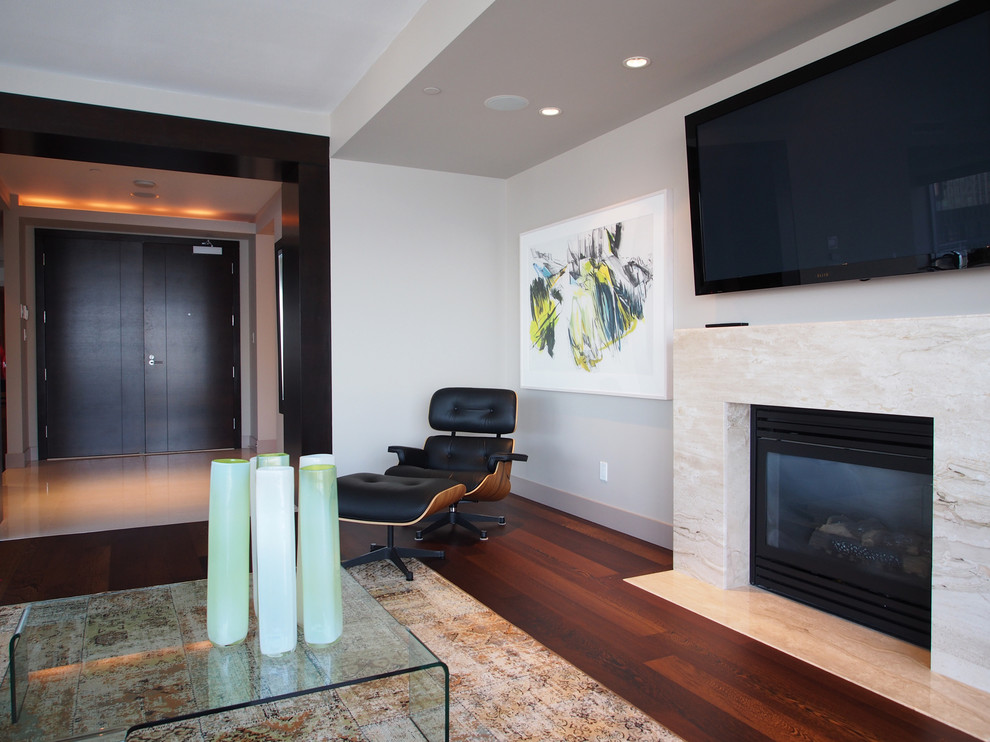 Стильный дизайн: гостиная комната в современном стиле с серыми стенами, стандартным камином и телевизором на стене - последний тренд