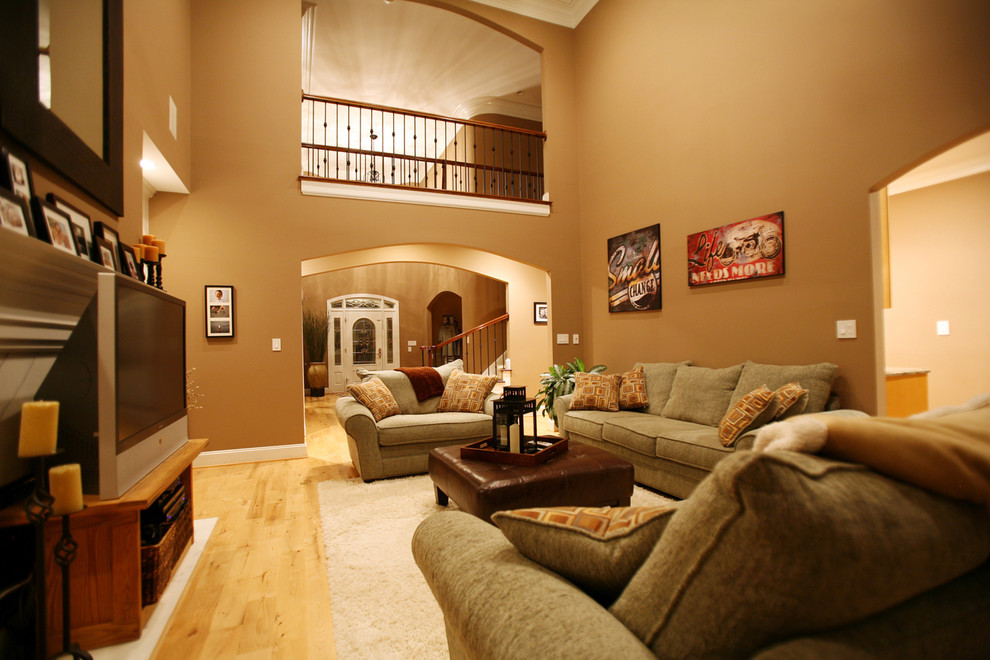 Großes, Offenes Klassisches Wohnzimmer mit brauner Wandfarbe, hellem Holzboden, Kamin, Kaminumrandung aus Stein und freistehendem TV in Charlotte