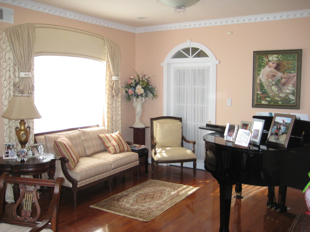 Idee per un piccolo soggiorno classico aperto con sala della musica, pareti rosa, pavimento in legno massello medio, nessun camino, nessuna TV e pavimento marrone