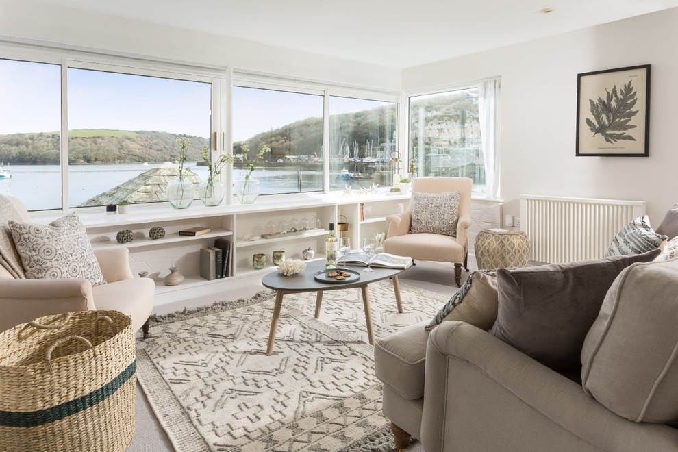 Immagine di un piccolo soggiorno stile marino chiuso con pareti beige, moquette, nessuna TV e pavimento grigio