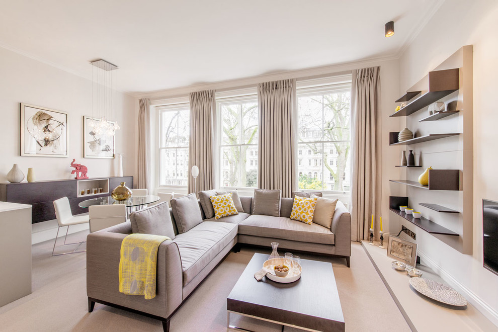 Large traditional grey and yellow living room in London with grey walls and a wall mounted tv.