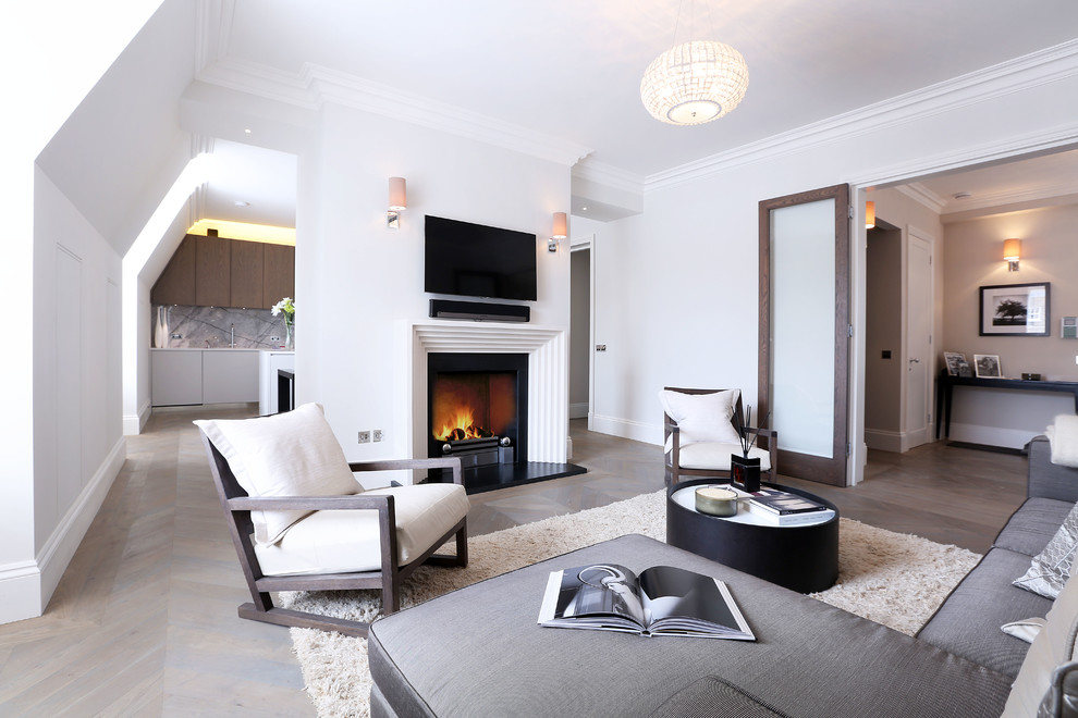Transitional formal light wood floor living room photo in London with white walls, a standard fireplace and a wall-mounted tv