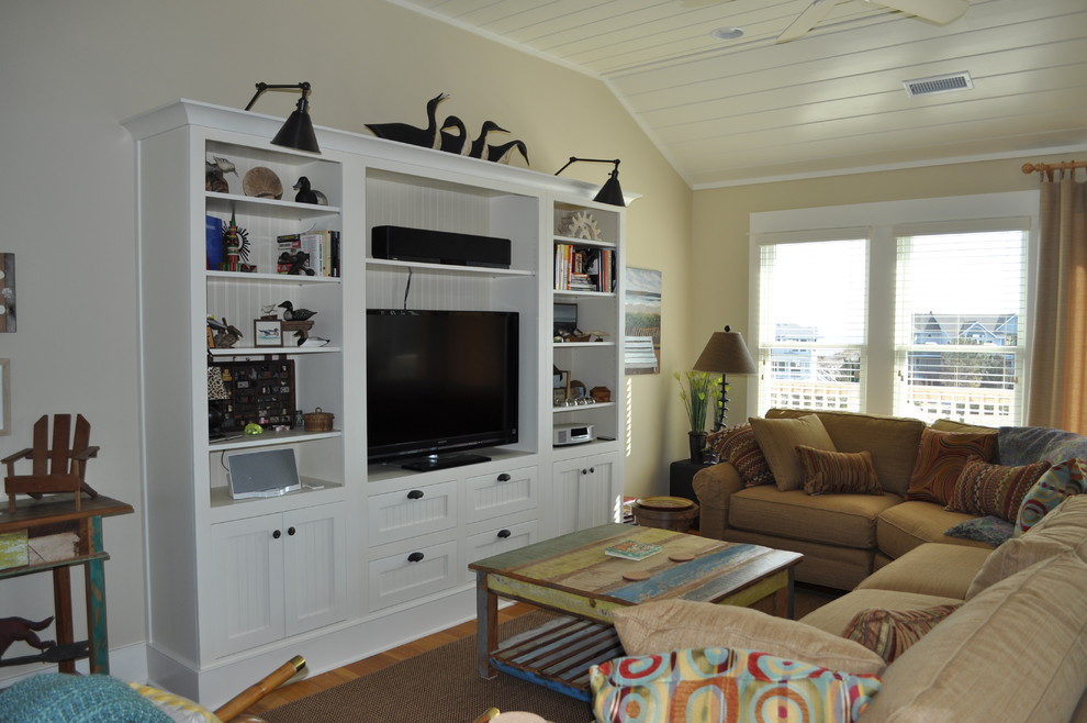 Ejemplo de salón abierto costero de tamaño medio con paredes blancas, suelo de madera en tonos medios y pared multimedia