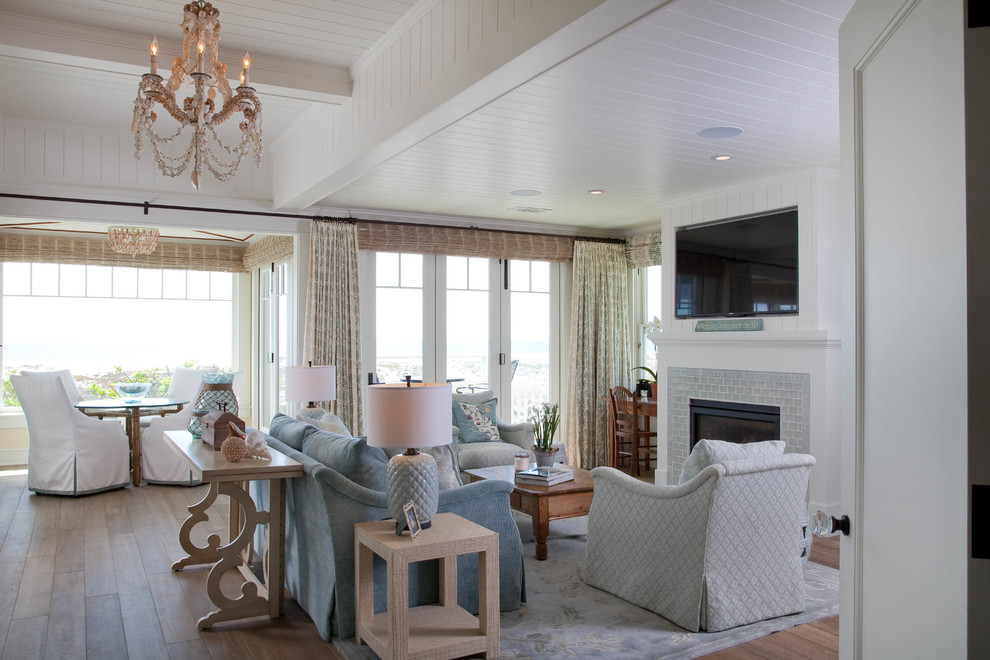 Living room - huge coastal open concept medium tone wood floor living room idea in San Diego with white walls, a standard fireplace, a wall-mounted tv and a brick fireplace