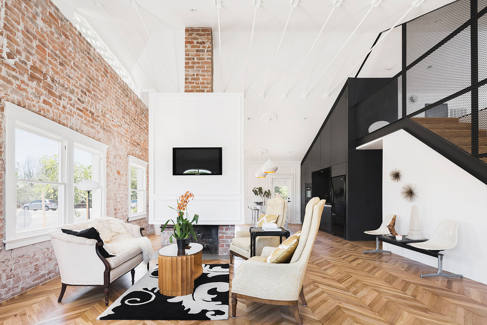 Immagine di un soggiorno contemporaneo aperto con pareti bianche, pavimento in legno massello medio, camino classico e cornice del camino in mattoni