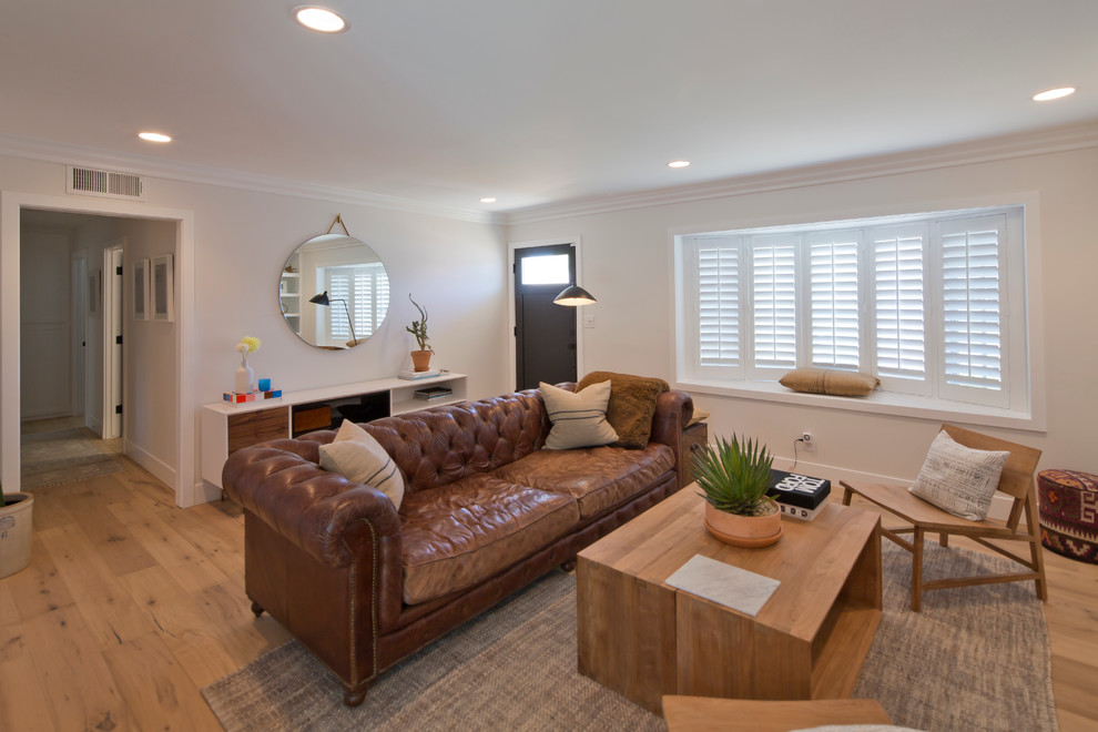 Esempio di un soggiorno minimalista di medie dimensioni e chiuso con sala formale, pareti beige, nessun camino, parete attrezzata e parquet chiaro