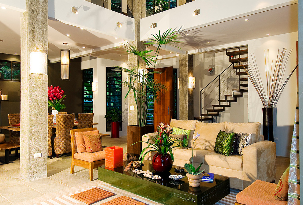 Immagine di un grande soggiorno tropicale aperto con sala formale, pareti beige, pavimento in travertino, nessun camino, nessuna TV e pavimento beige