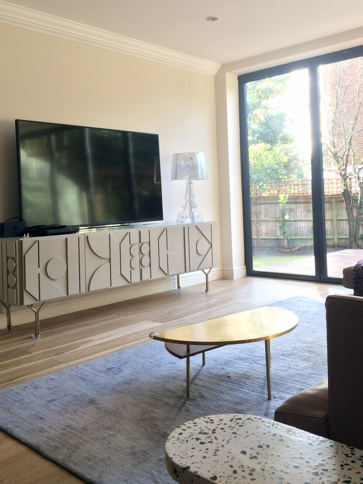Ispirazione per un grande soggiorno minimal aperto con pareti beige, parquet chiaro, TV autoportante e pavimento beige