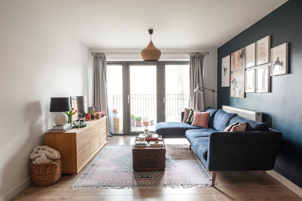 Идея дизайна: гостиная комната в стиле фьюжн с синими стенами, отдельно стоящим телевизором и коричневым полом