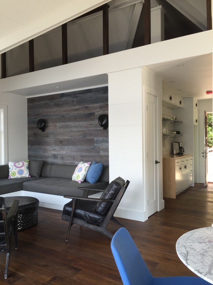 Immagine di un soggiorno design di medie dimensioni e stile loft con pareti bianche, pavimento in legno massello medio, camino ad angolo e cornice del camino in legno