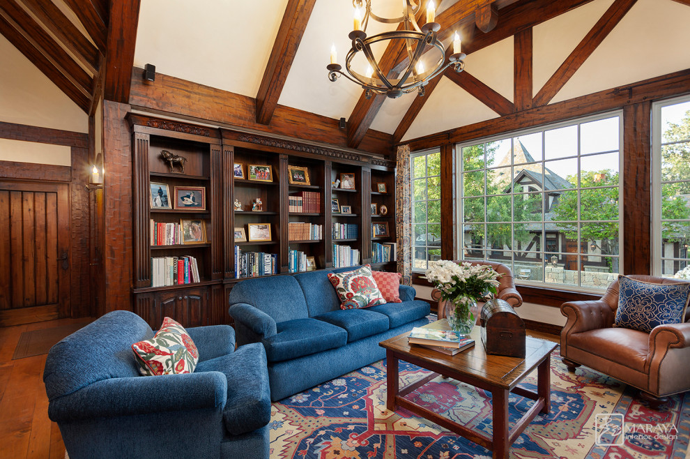 Inspiration for a medium sized rural mezzanine living room in Santa Barbara with a reading nook, beige walls, medium hardwood flooring, a standard fireplace, a stone fireplace surround, a concealed tv and brown floors.