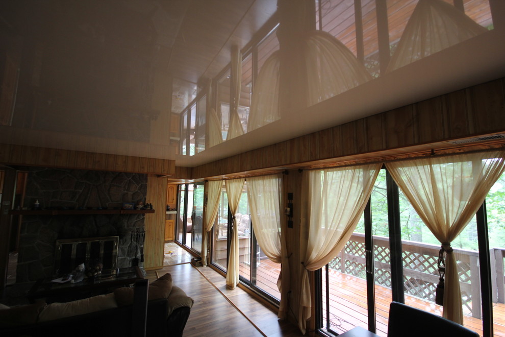 Immagine di un grande soggiorno classico aperto con pareti marroni, parquet chiaro, camino classico e cornice del camino in pietra