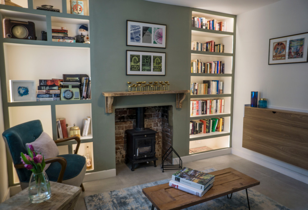 This is an example of a small scandi enclosed living room in Kent with green walls, porcelain flooring, a wood burning stove and grey floors.