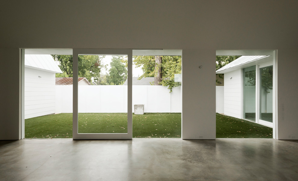 Идея дизайна: большая гостиная комната в стиле модернизм с белыми стенами и бетонным полом